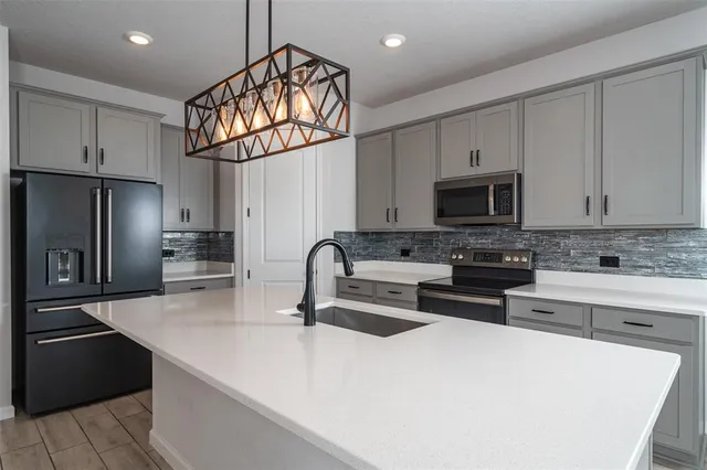 a kitchen with stainless steel appliances a sink cabinets and a refrigerator
