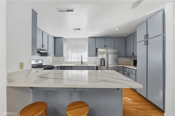 a kitchen with sink a stove and cabinets