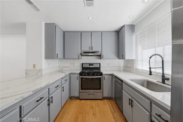 a kitchen with granite countertop a sink and refrigerator