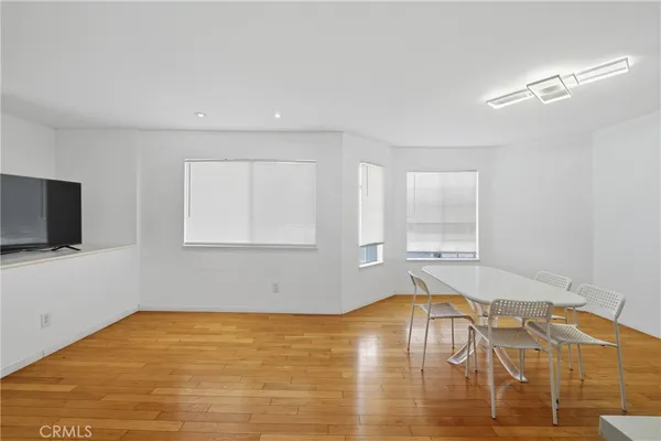 a kitchen with a table chairs a sink dishwasher stove and cabinets with wooden floor