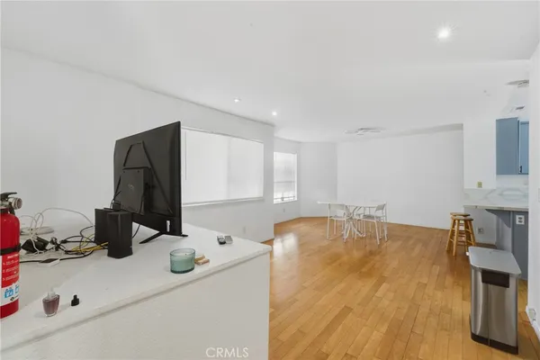 a large white kitchen with a dining table chairs and a refrigerator