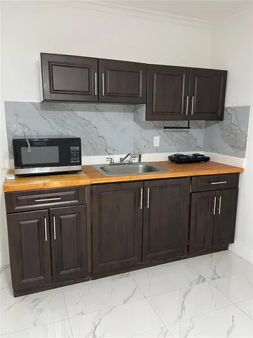 a kitchen with stainless steel appliances granite countertop wooden cabinets and a stove top oven