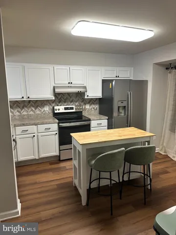 a kitchen with kitchen island a stove a sink dishwasher and a refrigerator