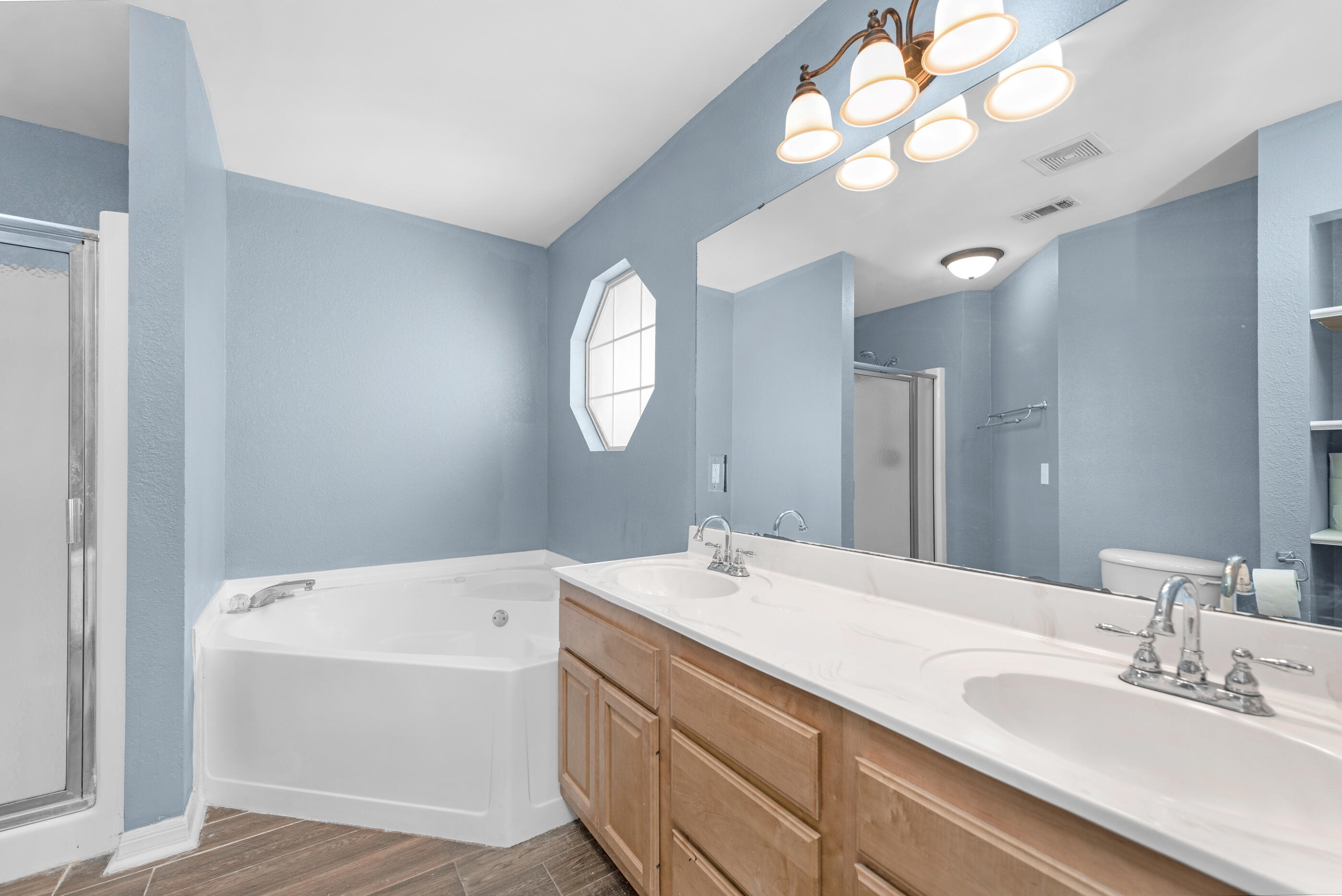 6664 Bellingham Street Navarre, FL 32566 - Photo 13 of 28 a bathroom with a sink a large mirror and a light fixture