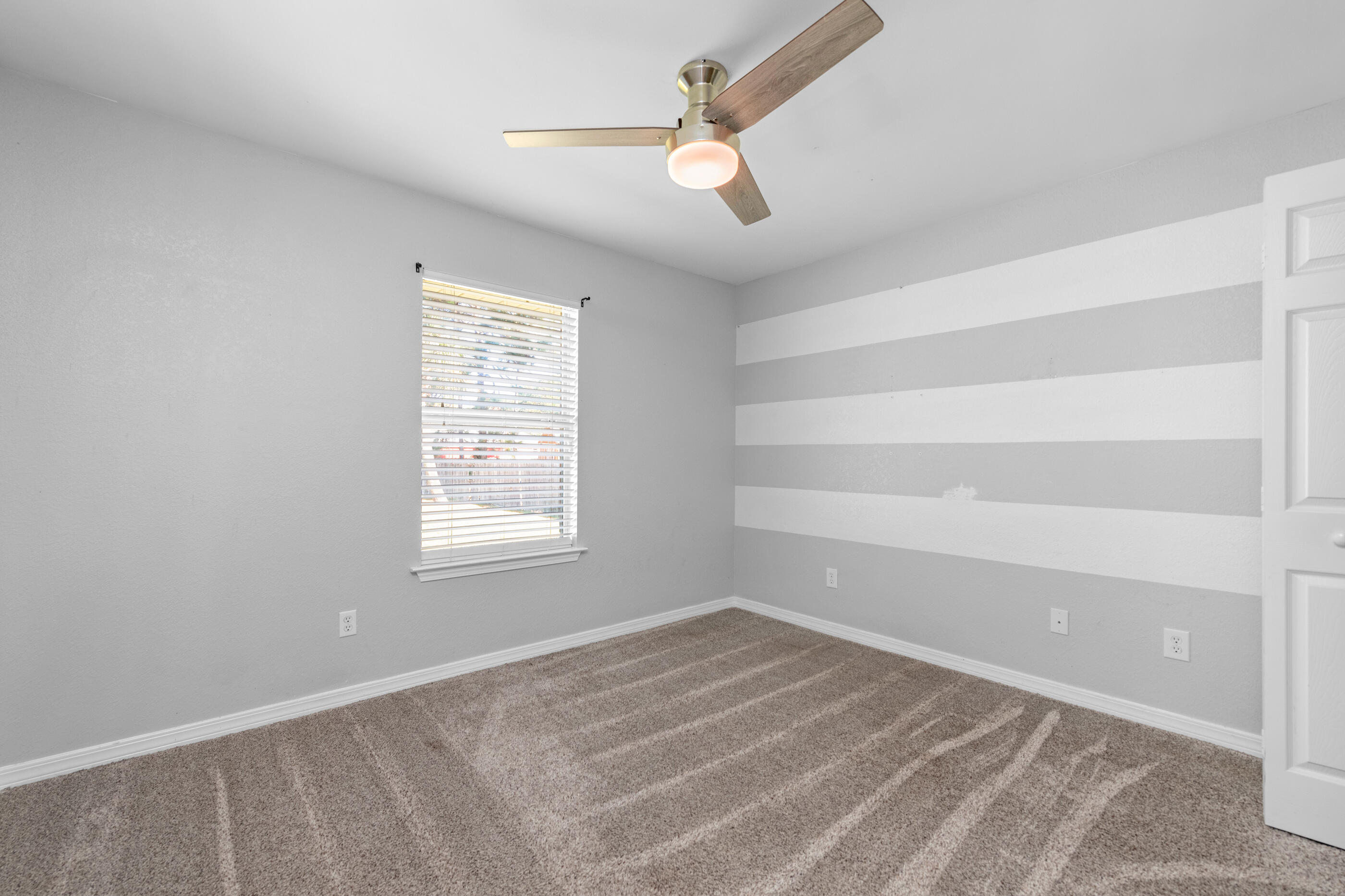 6664 Bellingham Street Navarre, FL 32566 - Photo 16 of 28 an empty room with a window and a fan