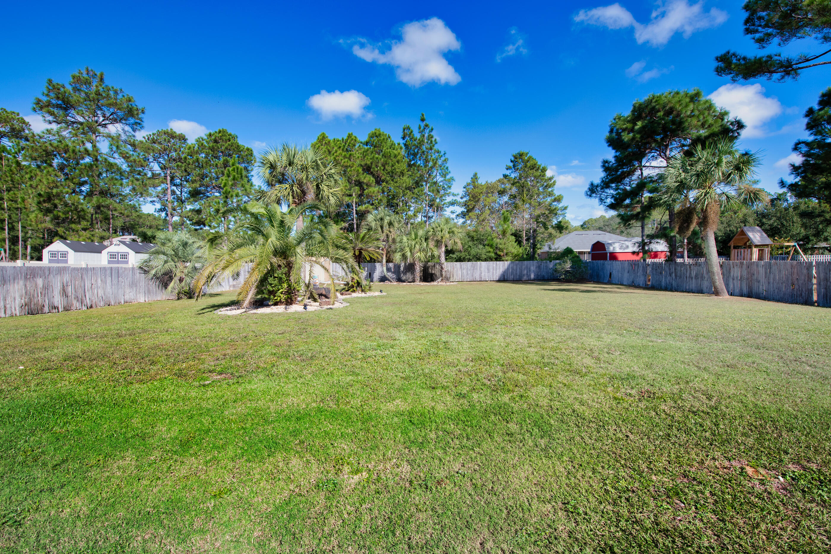 6664 Bellingham Street Navarre, FL 32566 - Photo 25 of 28 a view of a field of grass and trees