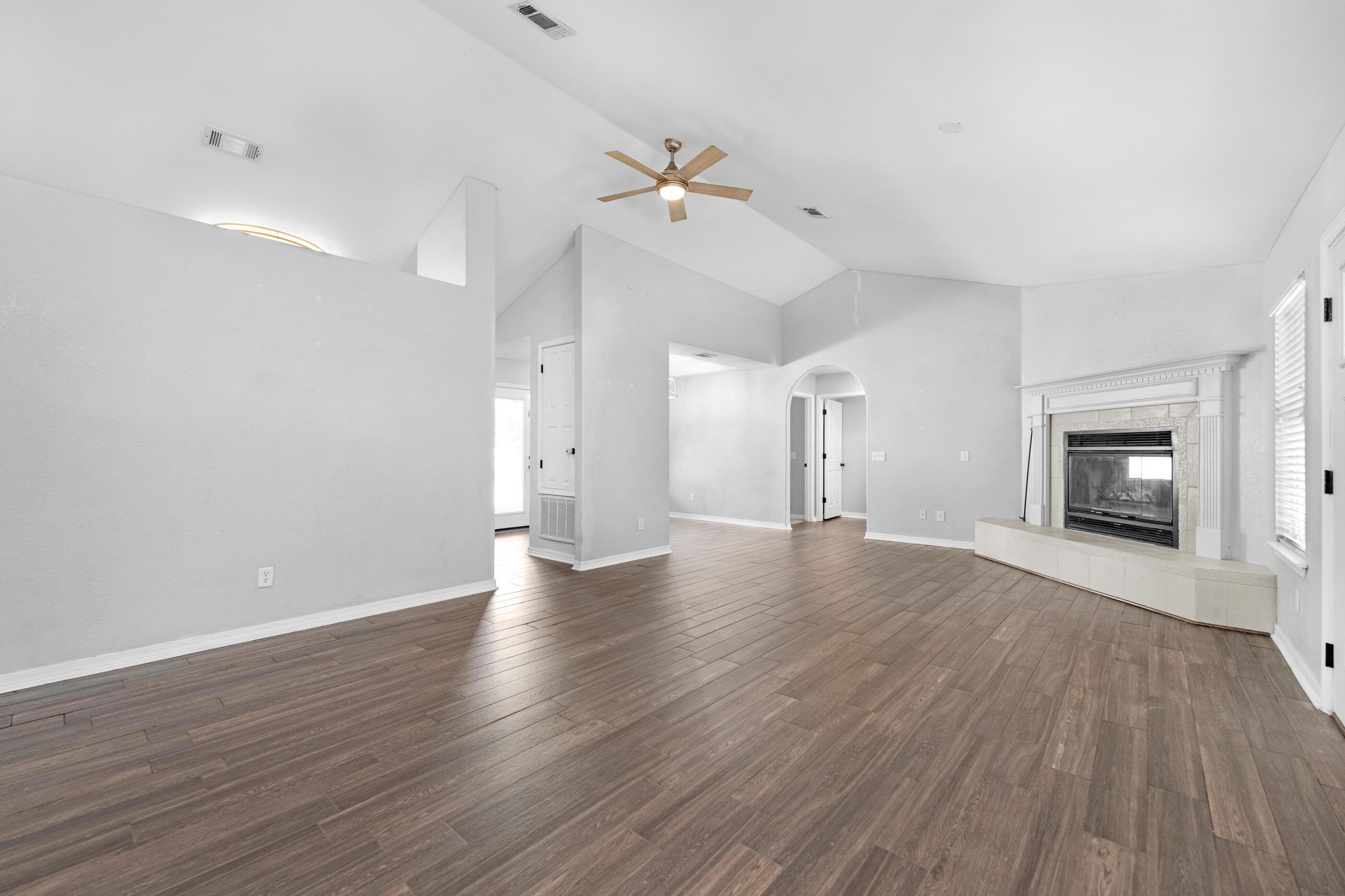 6664 Bellingham Street Navarre, FL 32566 - Photo 4 of 28 wooden floor in an empty room with a fireplace