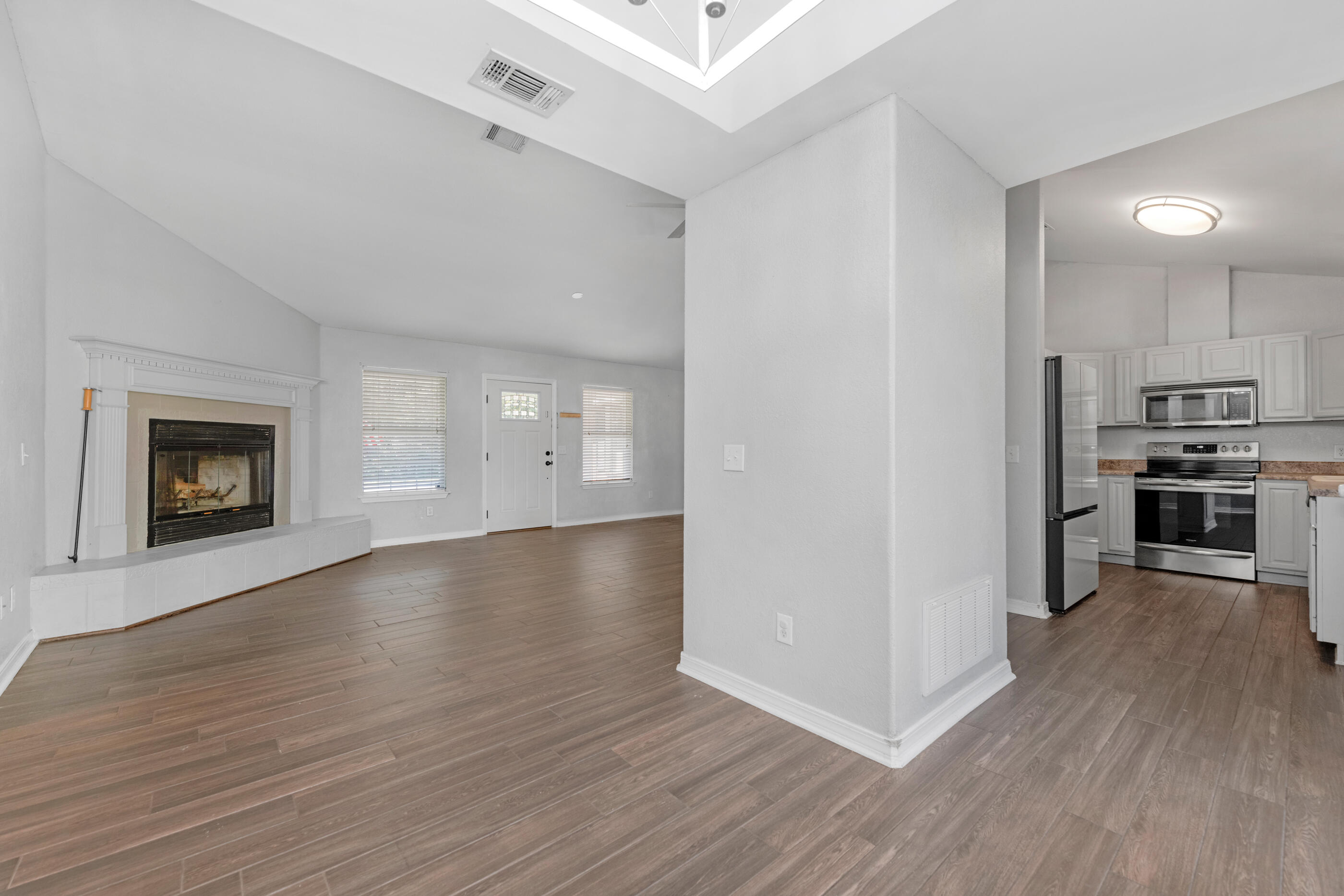 6664 Bellingham Street Navarre, FL 32566 - Photo 6 of 28 a view of a kitchen and an entryway with wooden floor