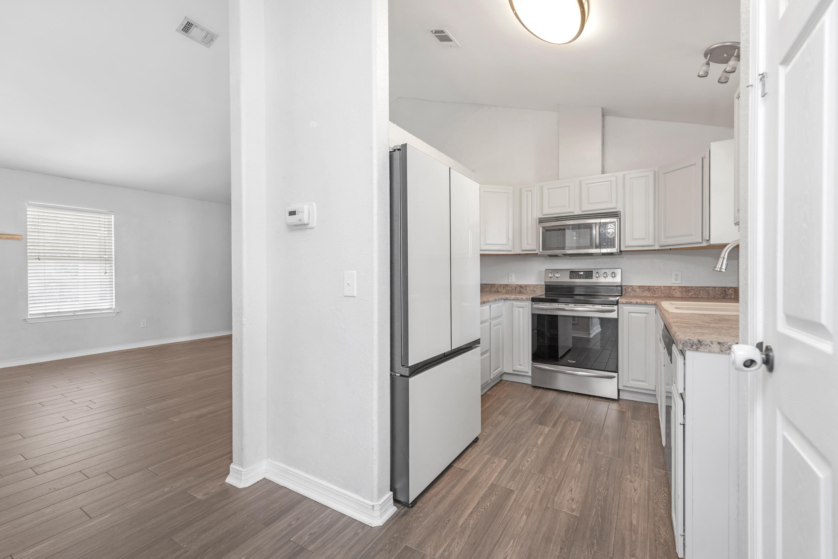 6664 Bellingham Street Navarre, FL 32566 - Photo 7 of 28 a kitchen with stainless steel appliances a refrigerator sink and microwave