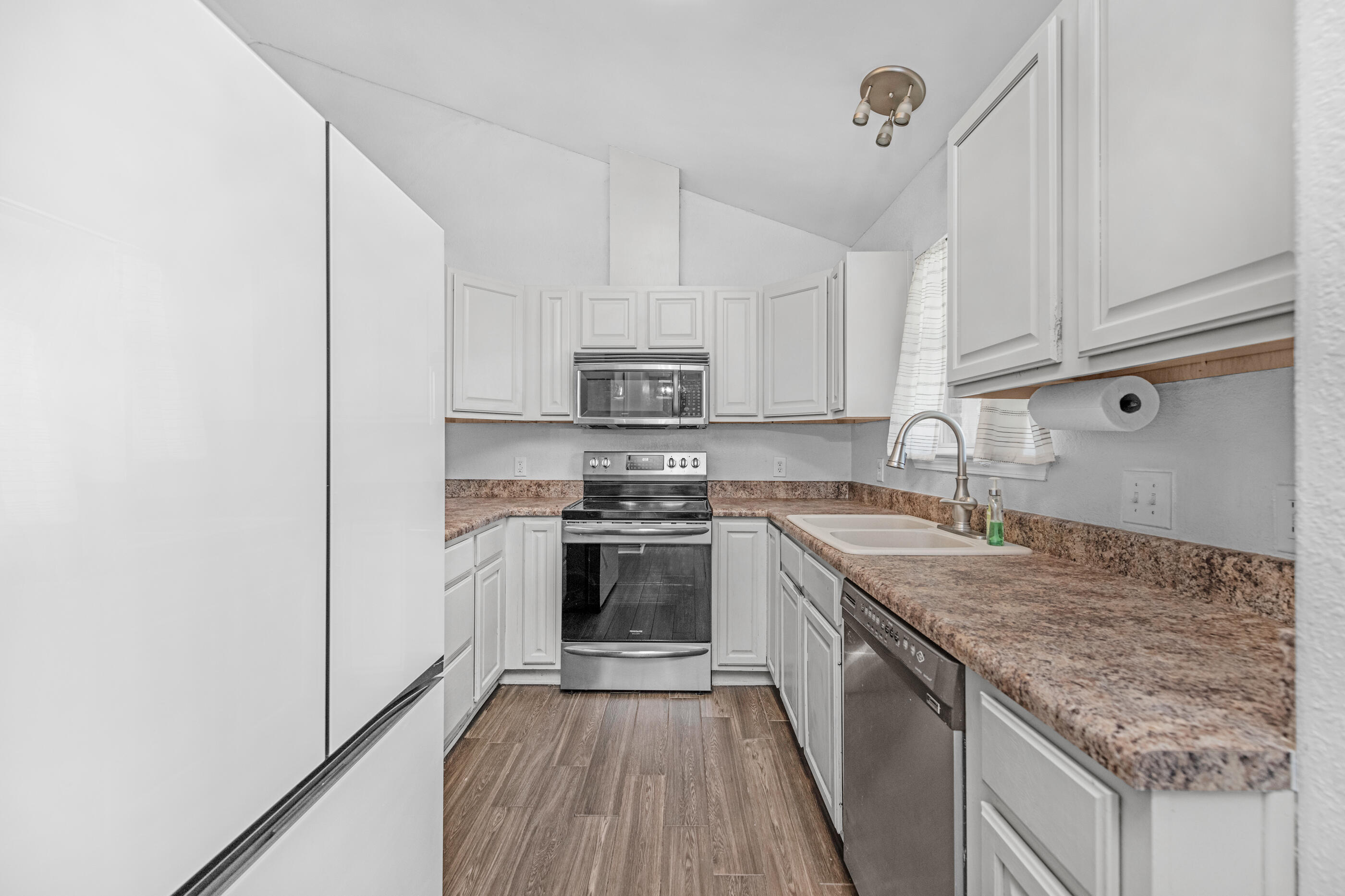 6664 Bellingham Street Navarre, FL 32566 - Photo 8 of 28 a kitchen with stainless steel appliances granite countertop a stove sink and cabinets