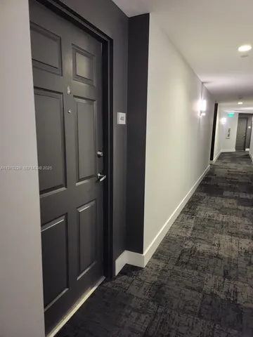 a living room with furniture potted plant floor to ceiling window and a flat screen tv