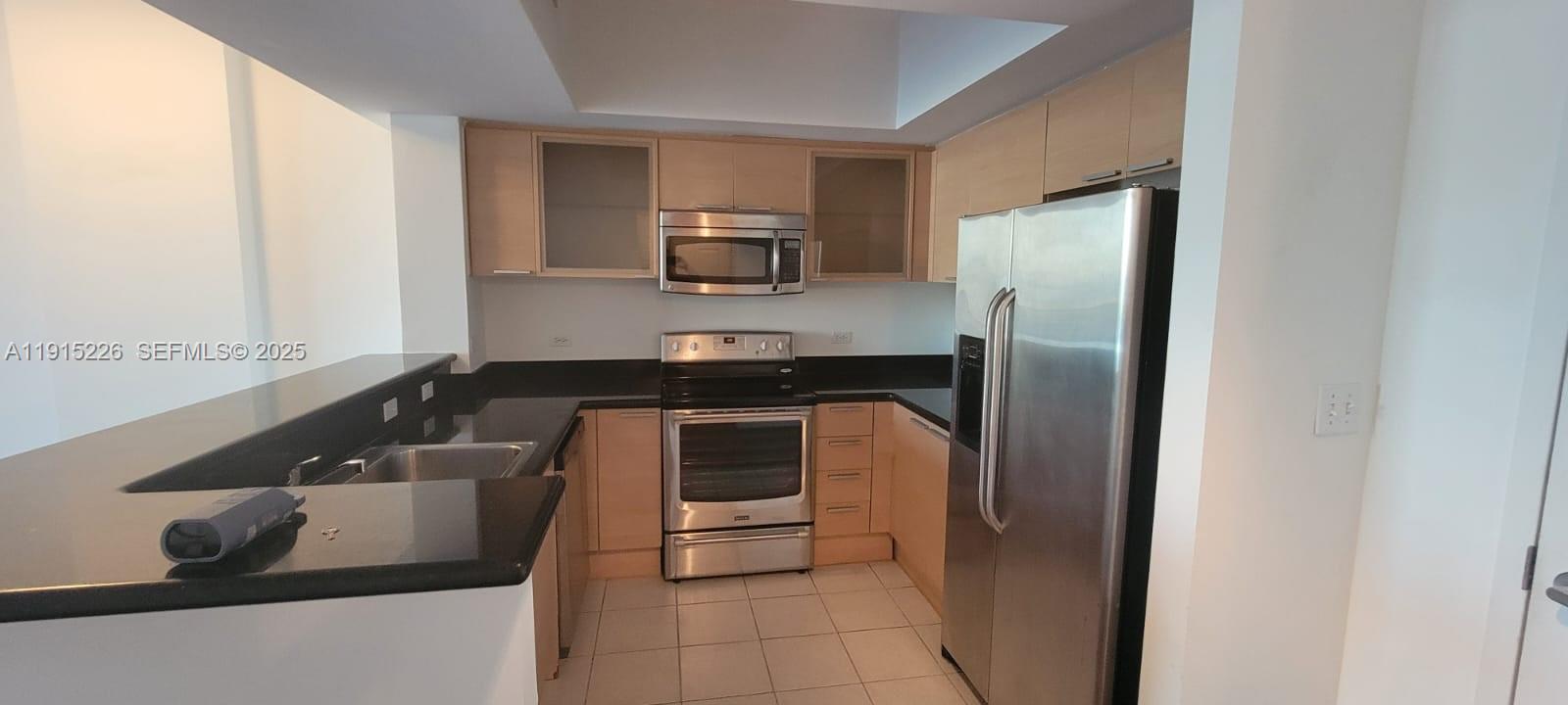 140 South Dixie Highway, Unit 423 Hollywood, FL 33020 - Photo 13 of 32 a kitchen with a sink and a refrigerator