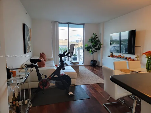 a view of a hallway with wooden floor and a living room