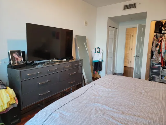 a bedroom with a bed and a flat screen tv