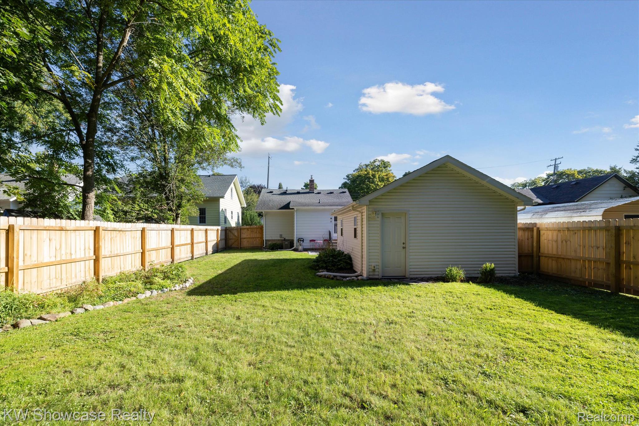 603 West Clinton Street Howell, MI 48843 - Photo 24 of 25 Rear view of house with a fenced backyard and an outbuilding