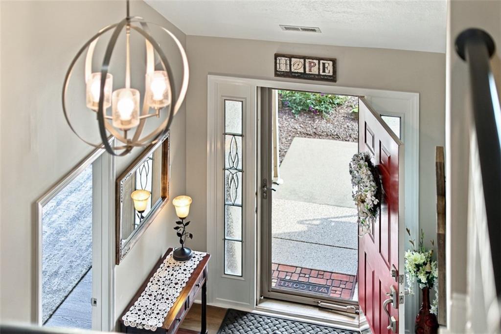 Welcoming foyer with decorative sidelights and an attractive open staircase.