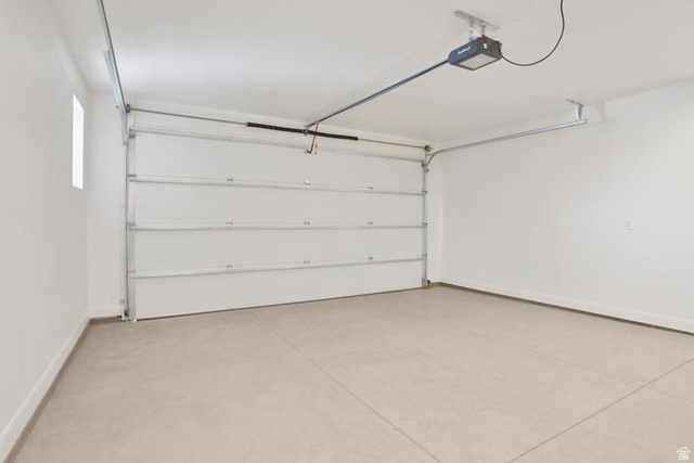 990 Manen Street Washington, UT 84780 - Photo 14 of 43 Spacious garage featuring a sectional overhead door, automatic opener, concrete flooring, and a high ceiling
