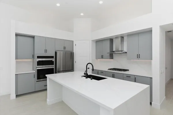 a kitchen with appliances a sink and cabinets