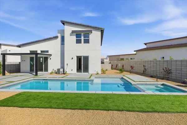 a view of a house with pool and a yard