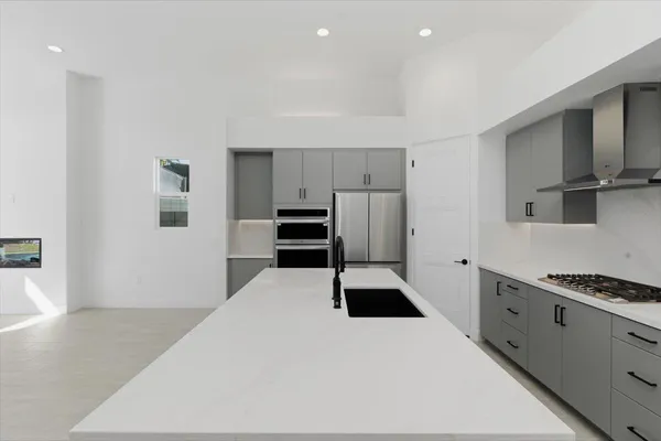 a kitchen with stainless steel appliances a refrigerator and a stove top oven