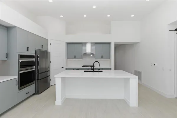 a kitchen with kitchen island a counter top space stainless steel appliances and cabinets