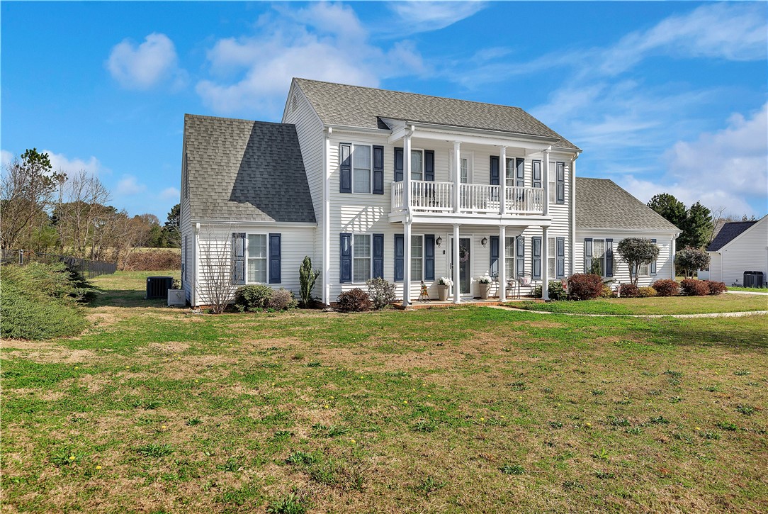 This charming residence features a classic two-story design with inviting outdoor living spaces.