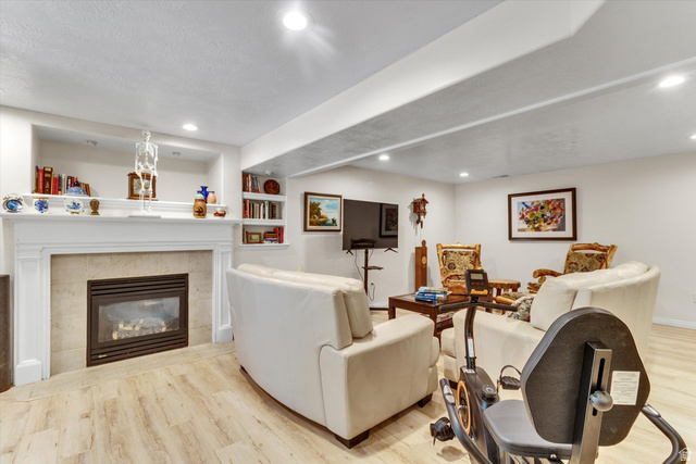 2863 Fallentine Road Sandy, UT 84093 - Photo 34 of 48 Living area with a built-in fireplace featuring a mantel and stone-tile surround