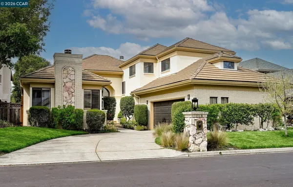 a front view of a house with a garden and plants
