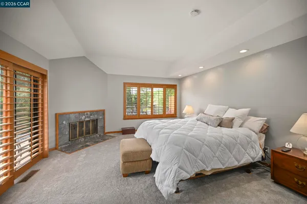 a bedroom with a bed fireplace and window