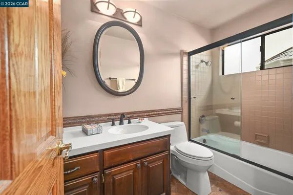 a bathroom with a sink a toilet and a mirror