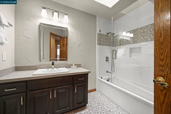 a bathroom with a double vanity sink mirror and a bathtub