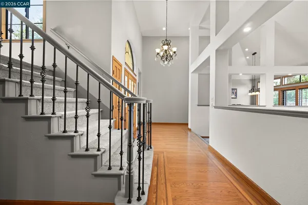 a view of staircase with lots of frames on wall and wooden floor