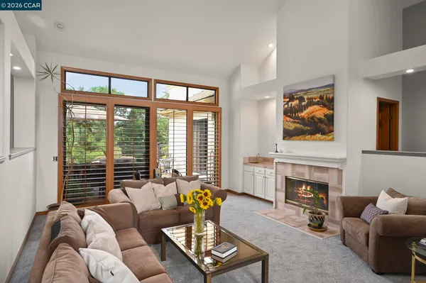 a living room with furniture a floor to ceiling window and a fireplace
