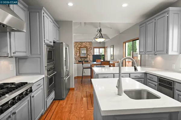 a kitchen with stainless steel appliances granite countertop a sink stove and refrigerator