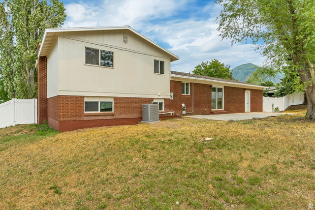 62 South Clark Lane Elk Ridge, UT 84651 - Photo 28 of 30 Rear exterior featuring a brick facade, white vinyl siding, and a concrete patio