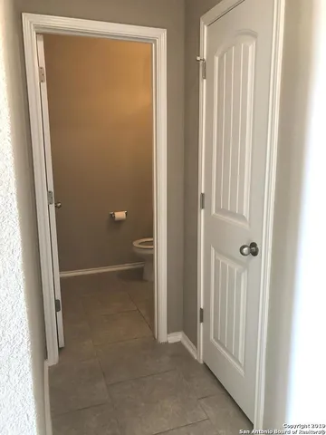 a view of an empty room with a kitchen and a window