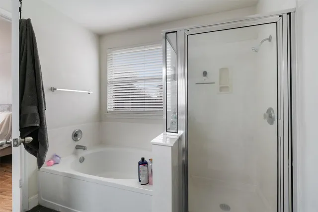 a bathroom with a bathtub a shower and a sink