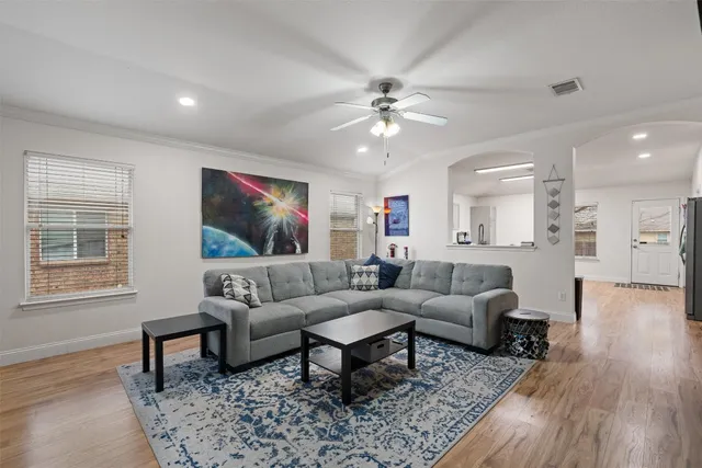 a living room with furniture and a wooden floor