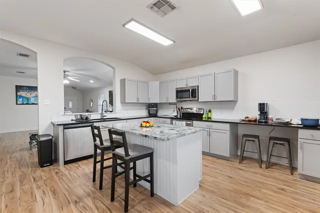 a kitchen with a table chairs microwave and cabinets