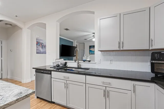 a kitchen with stainless steel appliances granite countertop a sink and a white cabinets
