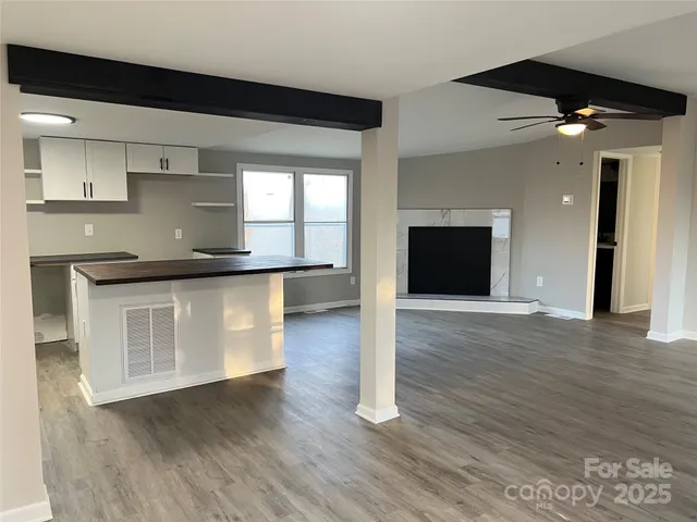 a kitchen with granite countertop a stove and a wooden floor
