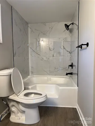 a bathroom with a toilet and a bath tub