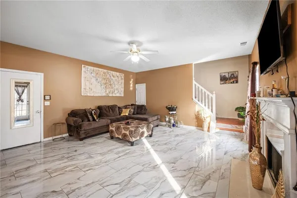 a living room with furniture a flat screen tv and a fireplace
