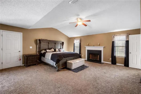 a spacious bedroom with a bed and a fireplace