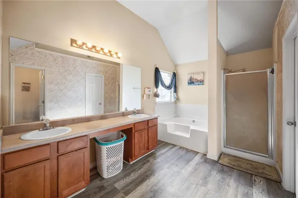 a spacious bathroom with a double vanity sink a large mirror and a shower