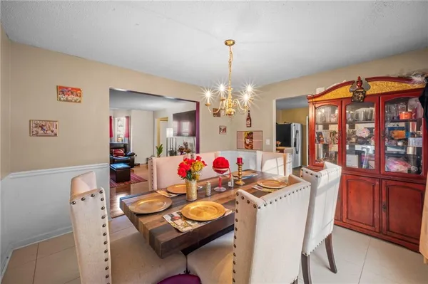 a view of a dining room with furniture a chandelier and wooden floor