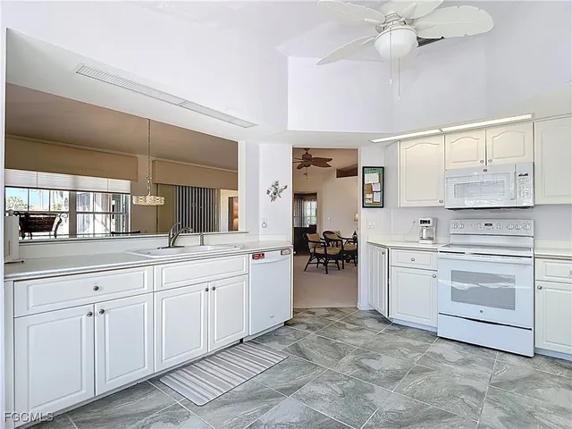 a spacious en suite bathroom with a granite countertop sink and a mirror