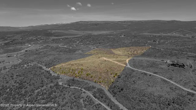 a view of a field with mountains in the background