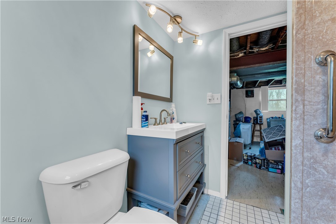 9642 Crow Road Litchfield, OH 44253 - Photo 37 of 50 Bathroom with a textured ceiling, vanity, toilet, and tile flooring