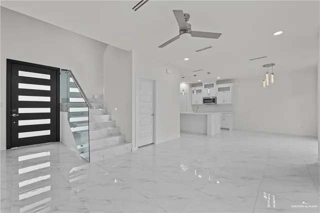 a view of a kitchen with kitchen island a sink stainless steel appliances and a counter top
